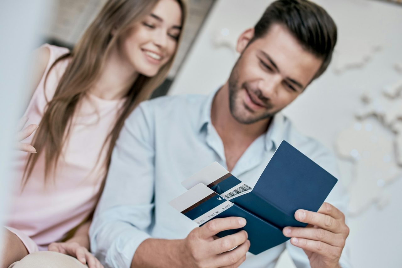 Young Man Smiling And Reviwing Tickets Passport With Visa 1 - Reliance Study Consultancy & Immigration